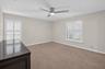 (FAN VIRTUALLY STAGED AS SIMILAR PIECE WILL BE INSTALLED) Neutral-toned interior featuring wall-to-wall carpeting, white plantation shutters, and a mo