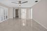 (FAN VIRTUALLY STAGED AS SIMILAR PIECE WILL BE INSTALLED) Interior space featuring high-gloss tile flooring, white plantation shutters, and a modern b