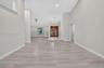 Open interior featuring vaulted ceilings, wood-finish flooring, double-door entryway, elevated stone-finish foyer landing, and a bay window