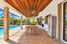 Covered outdoor patio featuring a wood-plank ceiling, recessed ceiling fans, brick-clad support columns, paver flooring, and an enclosed swimming pool
