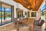 Covered patio featuring a stained wood plank ceiling, stone-style tile flooring, recessed ceiling fans, and sliding glass doors