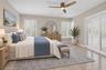 Neutral-toned bedroom featuring large-format tile flooring, plantation shutters, and a modern three-blade ceiling fan with integrated lighting