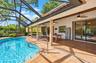 Screen-enclosed patio featuring a paver deck, brick support columns, recessed ceiling fans, and an inground pool with metal railings