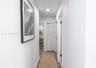 Hallway featuring recessed ceiling lighting, louvered bi-fold closet doors, and wood-finish flooring