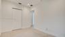 Interior space featuring wood-finish flooring, white walls, and a closet with bifold doors