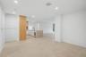 Open-concept interior featuring large-format tile flooring, recessed ceiling lighting, a kitchen island with a stone-finish countertop, integrated und