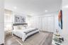 Wood-finish flooring, recessed lighting, and double-closet storage featuring white louvered doors