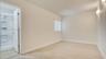 Neutral-toned room with wood-finish flooring, a vertical blind window covering, wall-mounted light fixtures, and a shower stall enclosure with a handh