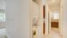 Laundry alcove featuring a stacked appliance unit, tiled flooring, and neutral wall finishes