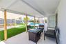 Covered patio featuring a solid-surface ceiling, natural wood support columns, tile flooring, and a swimming pool with a concrete pool deck