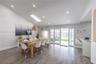 Vaulted ceiling with skylight, recessed lighting, wood-finish flooring, and white glass-pane French doors