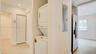 Laundry closet featuring a stackable washer and dryer, wood-finish flooring, recessed lighting, and a louvered bifold door