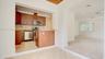 Kitchen featuring wood-finish cabinetry, stainless steel appliances, tile backsplash, and wood-finish flooring with a wood-plank ceiling accent