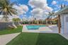 Outdoor space featuring an in-ground swimming pool, concrete pool deck, synthetic turf, and perimeter privacy fencing