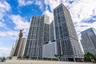High-rise residential tower featuring glass-curtain wall construction, expansive balconies, and geometric architectural detailing