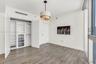 Wood-finish flooring, custom built-in closet system with integrated shelving and drawers, tiered drum pendant lighting, and floor-to-ceiling glass pan