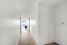 Hallway featuring wood-finish flooring, integrated floor-to-ceiling paneling, and recessed lighting