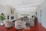 Living area featuring a floor-to-ceiling stone fireplace, wood-finish flooring, vaulted ceilings with recessed lighting, and arched patio access