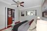 Wood-finish flooring, crown molding, built-in wooden closet cabinetry, and a ceiling fan with integrated lighting