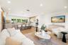 Open-concept living space featuring wood-finish flooring, recessed lighting, a central island with stone-finish countertops, handleless cabinetry, and