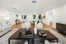 Open-concept interior featuring wood-finish flooring, recessed lighting, and a glass-paneled entry door