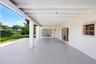 Covered patio featuring a painted wood-beam ceiling, concrete flooring, sliding glass doors, and French doors