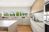Kitchen featuring flat-panel cabinetry, wood-finish flooring, stone-finish countertops and backsplash, integrated stainless steel appliances, and a ho