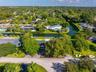 Aerial perspective featuring a waterfront property with a private swimming pool, mature tree canopy, and direct waterway access