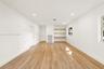 Neutral interior space featuring wood-finish flooring, recessed lighting, and built-in wall shelving