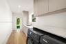 Utility area featuring flat-panel cabinetry, light-toned stone-finish countertops, an undermount sink with a gooseneck faucet, and wood-finish floorin