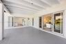 Covered patio featuring an exposed-beam ceiling, solid-surface flooring, and glass-paneled doors