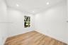 Room featuring wood-finish flooring, recessed lighting, and a single window with exterior greenery