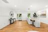 Open interior featuring wood-finish flooring, recessed lighting, and a white-framed glass paneled entry door