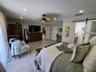 Wood-finish flooring, recessed lighting, ceiling fan with light fixture, and sliding barn-style door