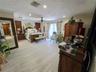 Spacious interior featuring wood-finish flooring, recessed lighting, crown molding, vertical wall paneling, and sliding glass doors