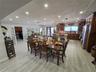 Open-concept kitchen and dining area featuring wood-finish flooring, recessed lighting, stained wood cabinetry, a center island, and French doors