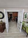 White French doors featuring multi-pane glass inserts, wood-finish flooring, and built-in wood cabinetry
