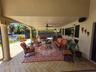 Covered patio featuring herringbone-pattern paver flooring, recessed lighting, ceiling fans, and an arched architectural column