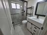 White vanity with a rectangular sink, matte black hardware, and an integrated countertop