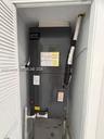 Vertical HVAC air handler unit enclosed within a closet featuring louvered bi-fold doors