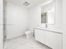Modern bathroom featuring a floating vanity with a seamless countertop, rectangular sink, polished-edge mirror, and floor-to-ceiling tiled shower with