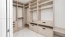 Custom walk-in closet featuring extensive built-in shelving, integrated storage drawers, hanging rods, and large-format tile flooring