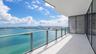Covered balcony featuring white tiled flooring, metal-framed glass railings, and floor-to-ceiling glass wall panels