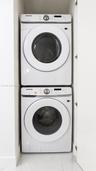Stacked white Samsung front-loading laundry units housed within a dedicated closet