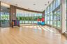 Fitness studio featuring floor-to-ceiling glass walls, wood-finish flooring, full-length mirror wall, and wood slat accent wall