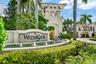 Entry monument with mosaic tile detailing, water feature with multiple fountains, and lush landscaping