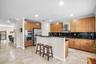 Kitchen featuring wood-finish cabinetry, stainless steel appliances, granite countertops / backsplash, wall ovens and pantry