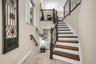 Multi-level interior featuring wood-finish stair treads and wrought iron staircase