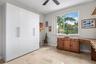 Wood-finish built-in desk, ceiling fan and barn door at walk-in closet