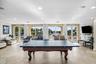 Expansive recreational space featuring a billiards table, recessed lighting, and direct access to an outdoor patio with water frontage